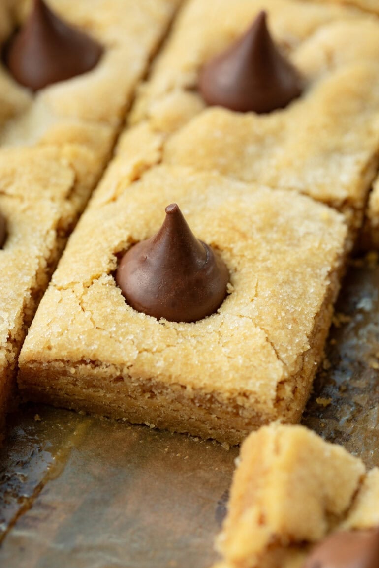 a pan of baked peanut butter blossom bars topped with whole hersey's kisses