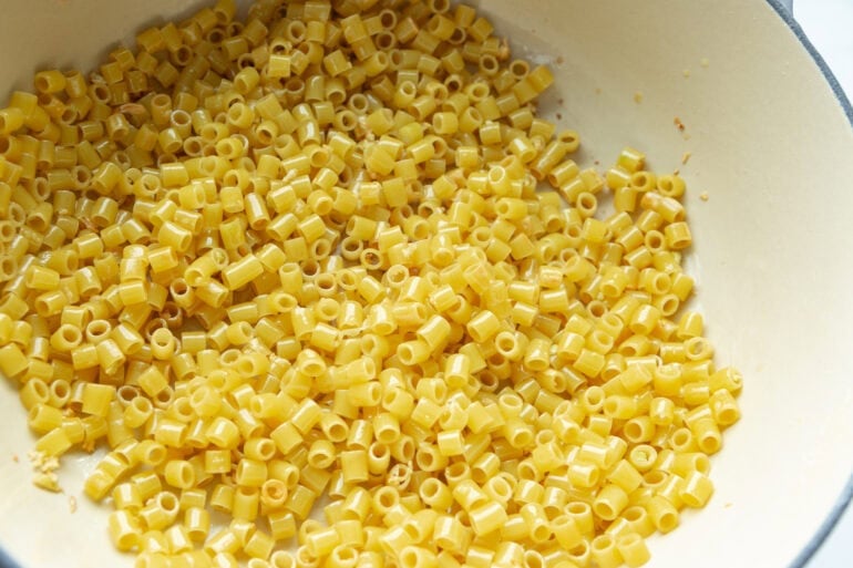 Angled close-up of noodles coated in butter and Parmesan in a dutch oven