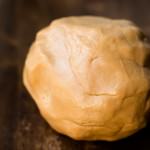 Delicious rolled up ball of edible peanut butter playdough on a wooden table.