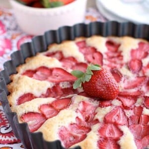 Strawberry Cake - this from scratch cake is cooked with layered strawberries for a stunning, lightly sweet cake that is best served with a side of sweetened coconut whipped cream. Recipe by Amber at DessertNowDinnerLater.com for Oh Sweet Basil.