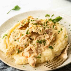 Slow cooker pork chops shredded over creamy mashed potatoes with gravy