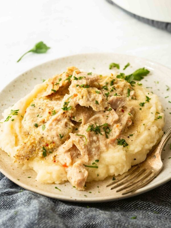 Slow cooker pork chops shredded over creamy mashed potatoes with gravy
