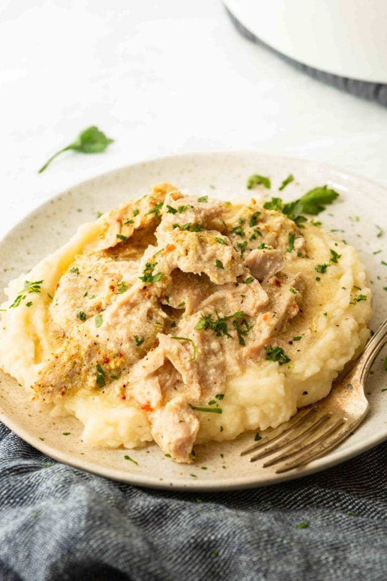 Slow cooker pork chops shredded over creamy mashed potatoes with gravy