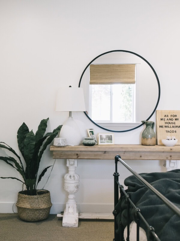 Urban Outfitters Black Round Mirror over a simple side table with a modern floor plant #modern #bedroomUrban Outfitters Black Round Mirror over a simple side table with a modern floor plant