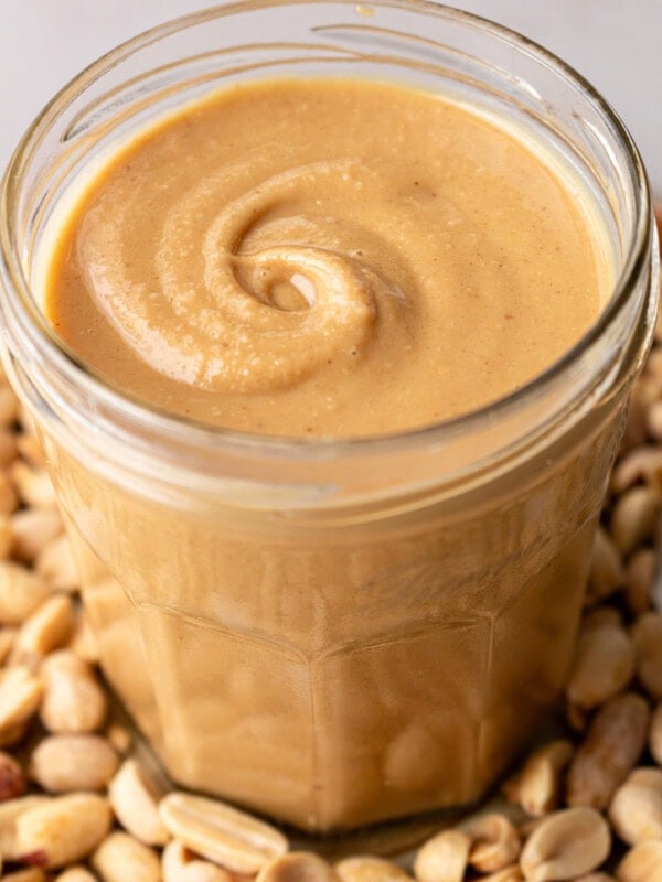 a photo of a glass jar full of creamy coconut peanut butter