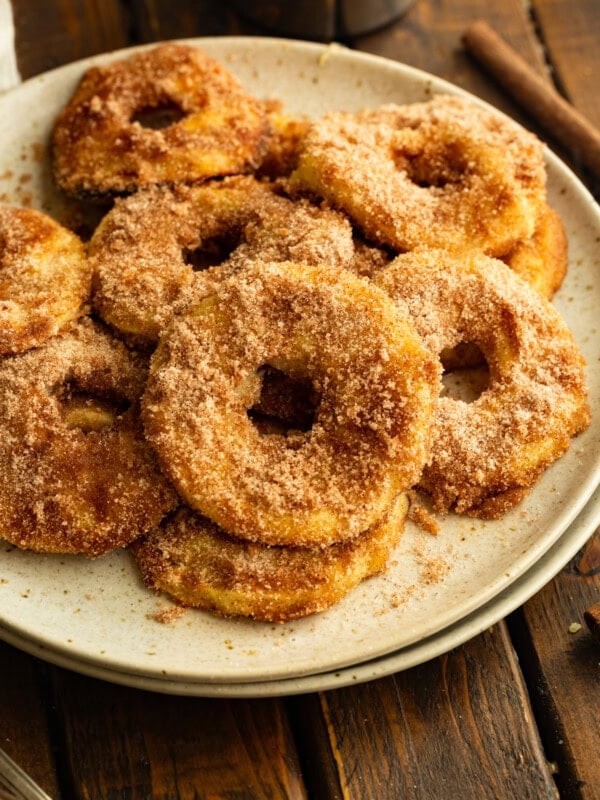 several air fried apple rings coated in golden batter and cinnamon sugar sitting on a plate
