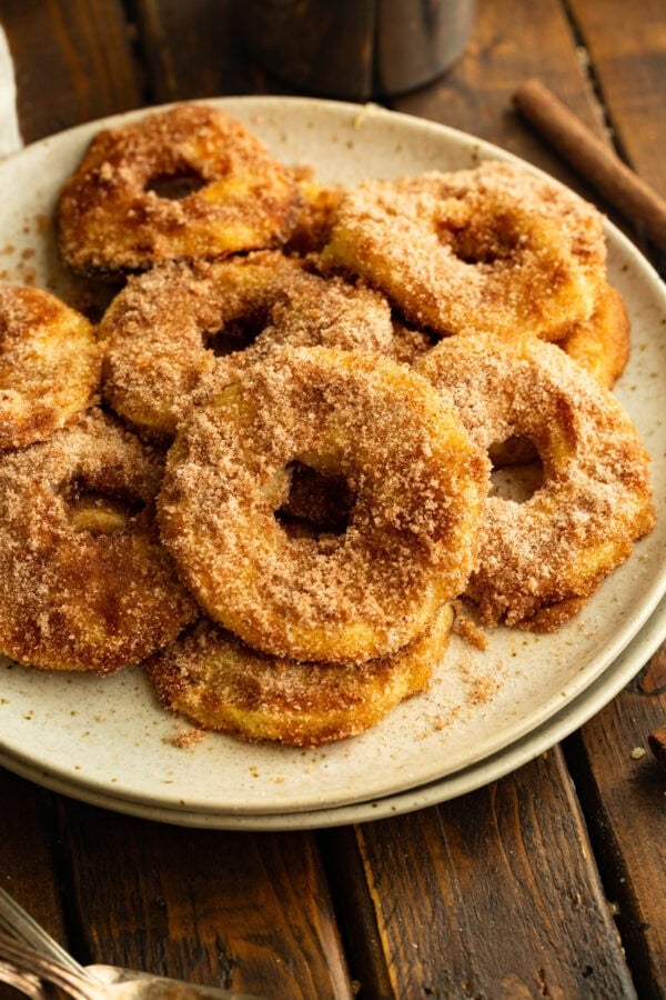 several air fried apple rings coated in golden batter and cinnamon sugar sitting on a plate