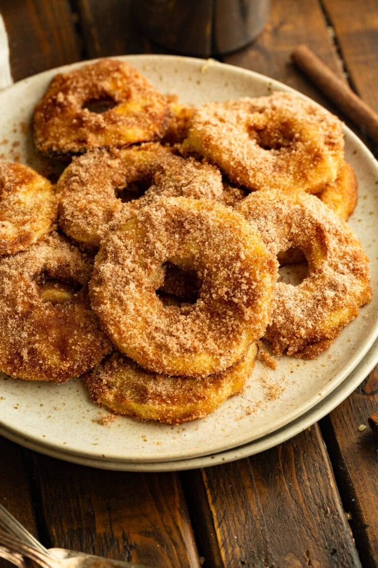 several air fried apple rings coated in golden batter and cinnamon sugar sitting on a plate