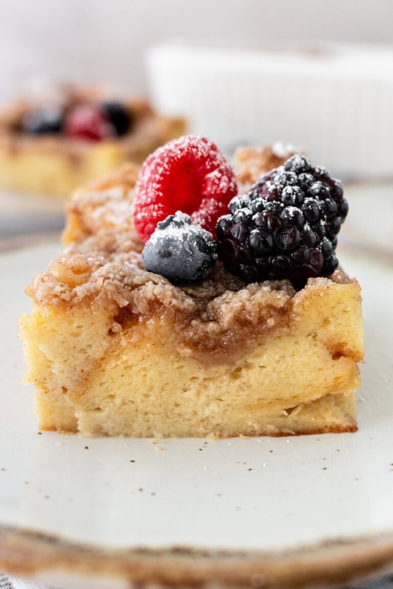 a photo of a piece of french toast casserole topped with fresh berries