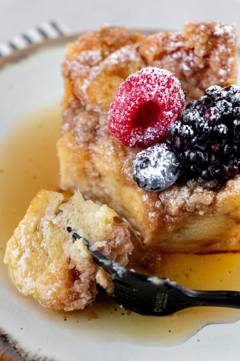 A photo of a piece of French toast casserole being taken out with a fork