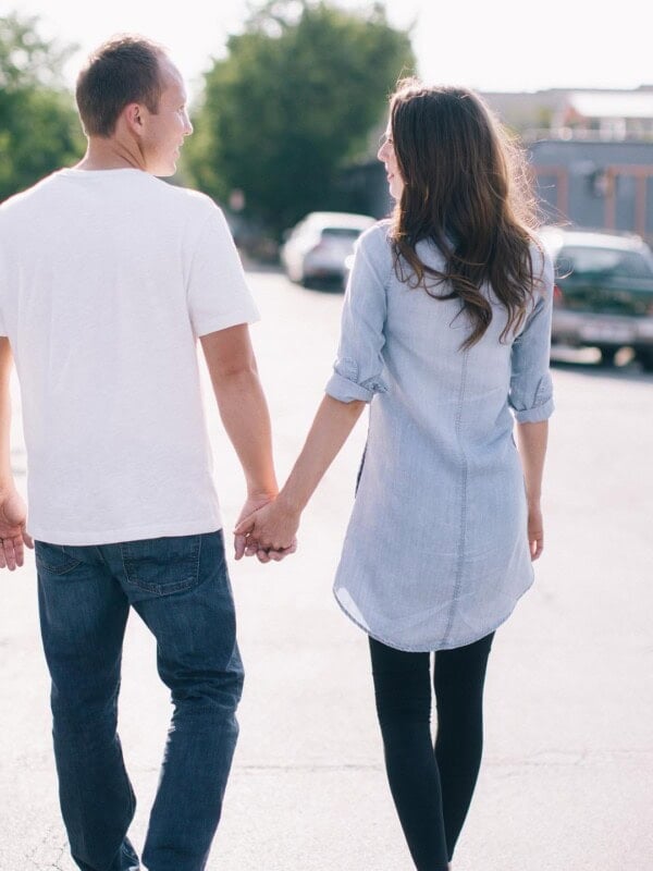 A photo of Cade and I holding hands, walking, and looking at each other taken from behind us.