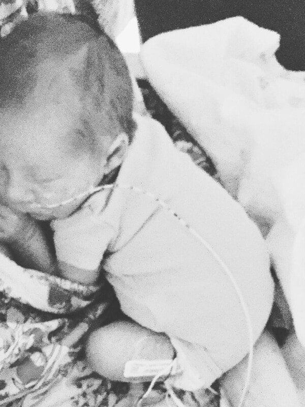 A photo of our new little baby boy curled up on my chest.