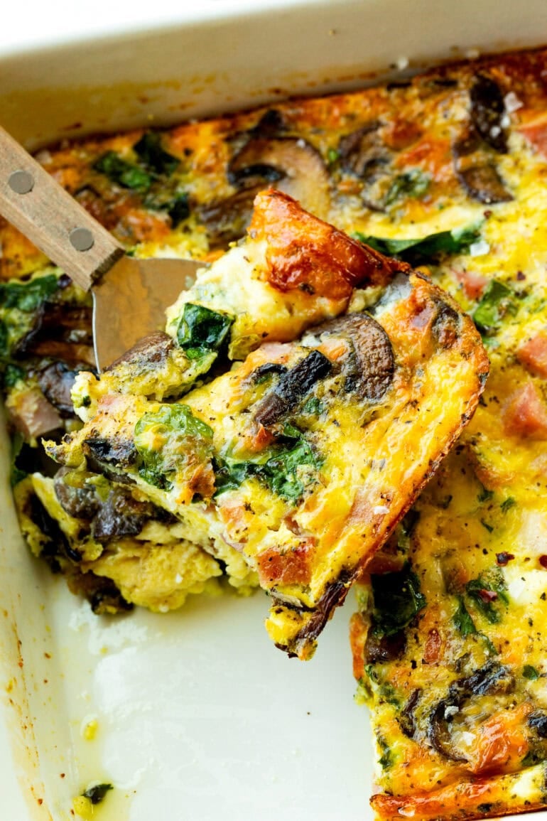 a spatula lifting a piece of breakfast egg casserole from a pan