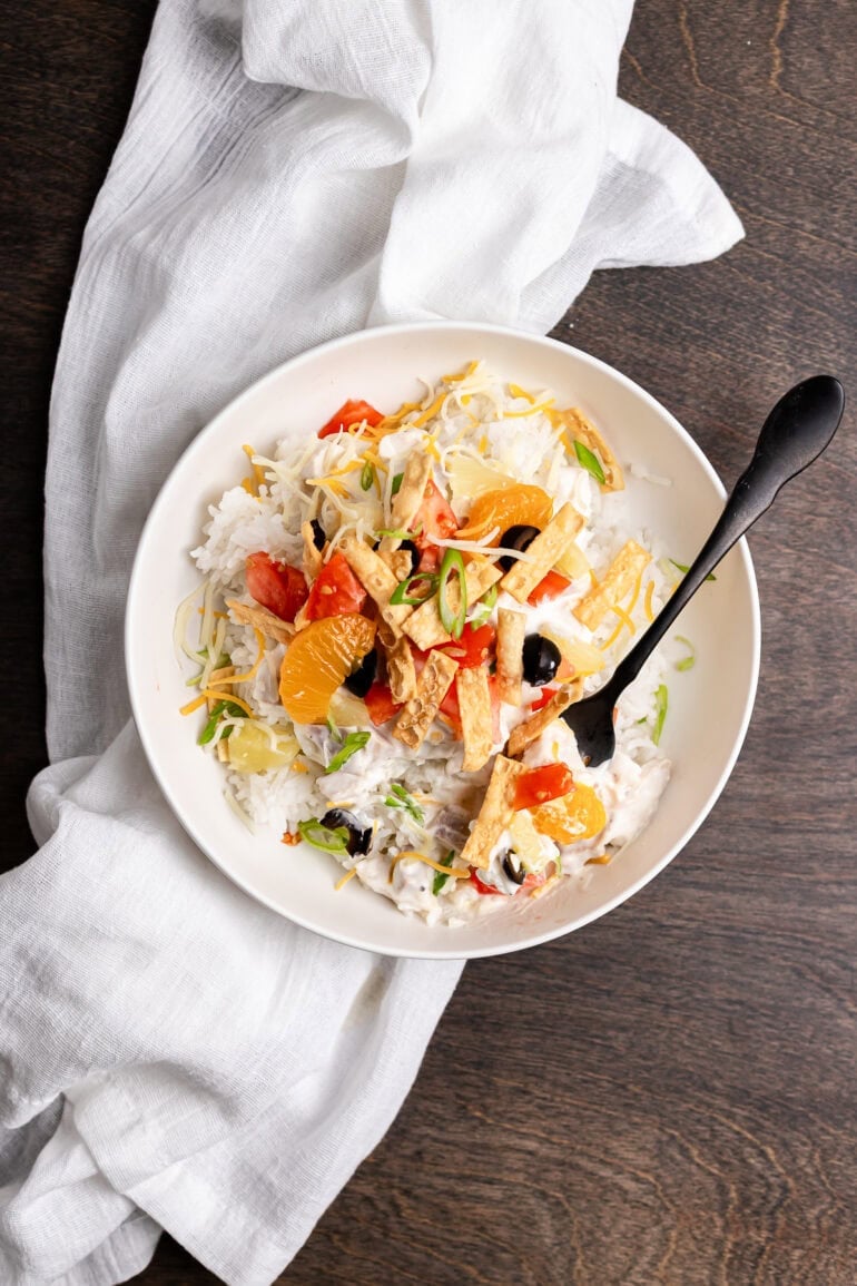 Hawaiian Haystacks served in a clean white bowl with fluffy rice, creamy chicken sauce, pineapple, and crispy wonton strips.