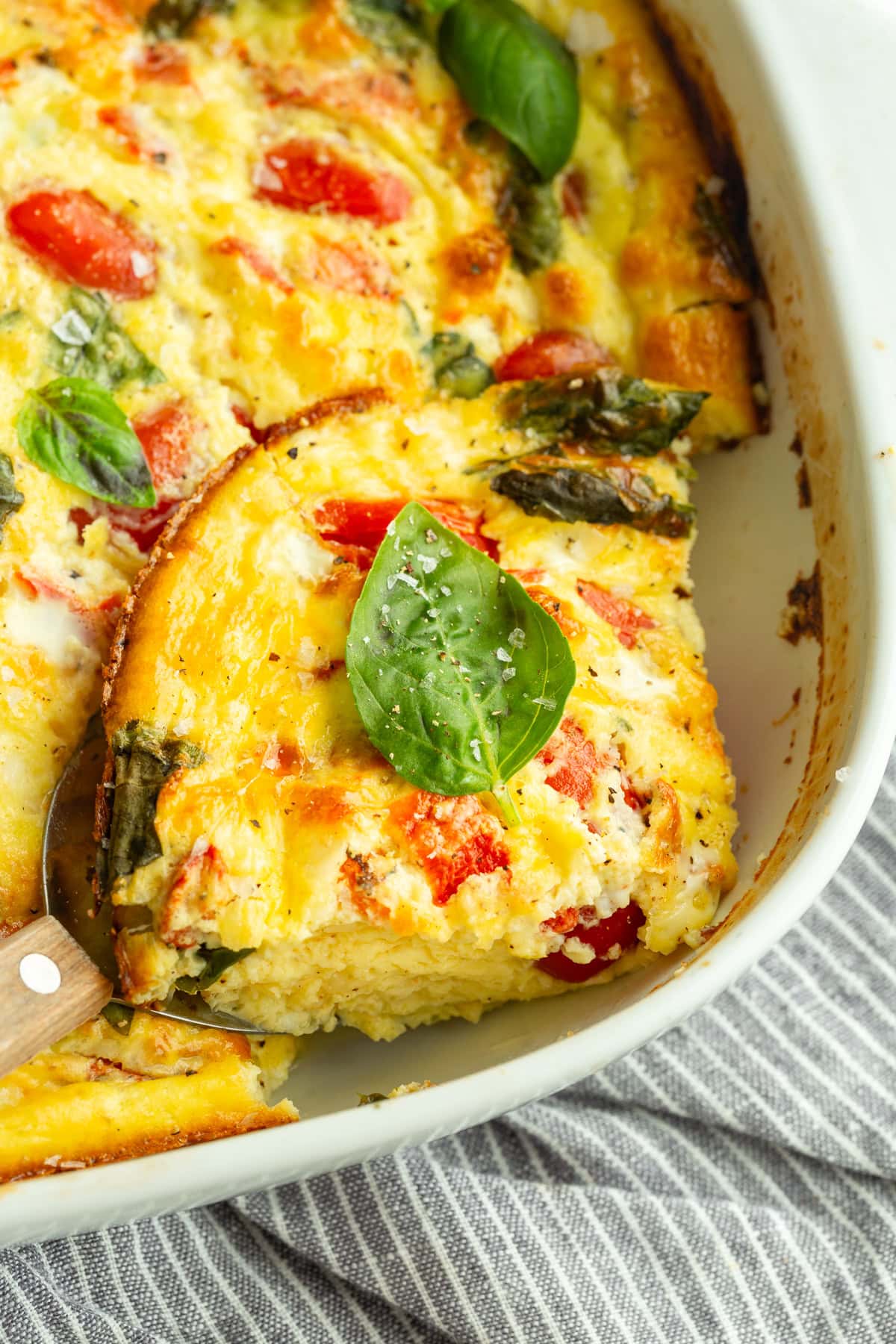 a serving of cottage cheese egg bake removed from a baking dish full of the casserole