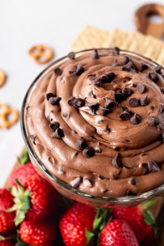 a photo of a glass bowl full of brownie batter dip topped with minute chocolate chips