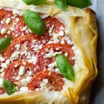 This Mozzarella Tomato Tart has a butter-garlic phyllo crust with mozzarella, tomatoes, feta, and basil. Makes a great appetizer or light meal for summer!