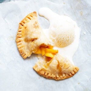 a grey platter with a cup open peach hand pie and a scoop of vanilla ice cream