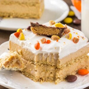 A slice of creamy peanut butter icebox cake with whipped topping and peanut butter cups.