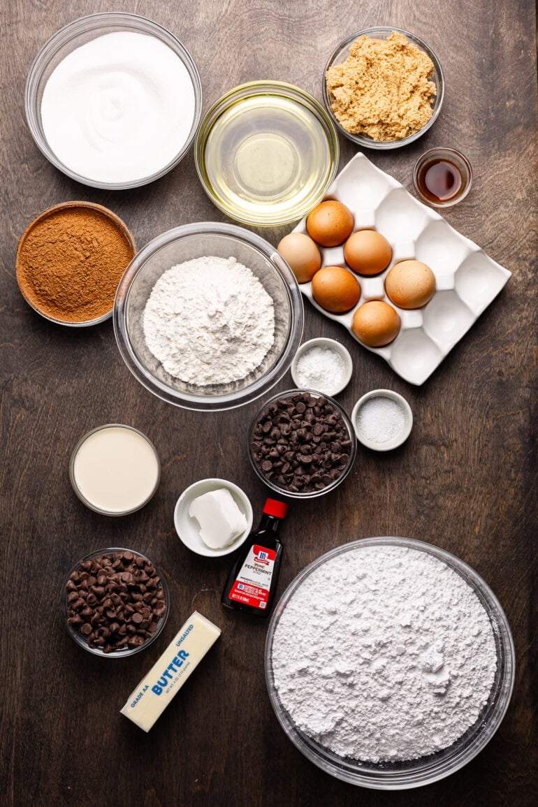 all the ingredients for peppermint brownies in separate small bowls and containers including flour, sugar, eggs, salt, baking soda, cocoa powder, chocolate chips, oil etc.