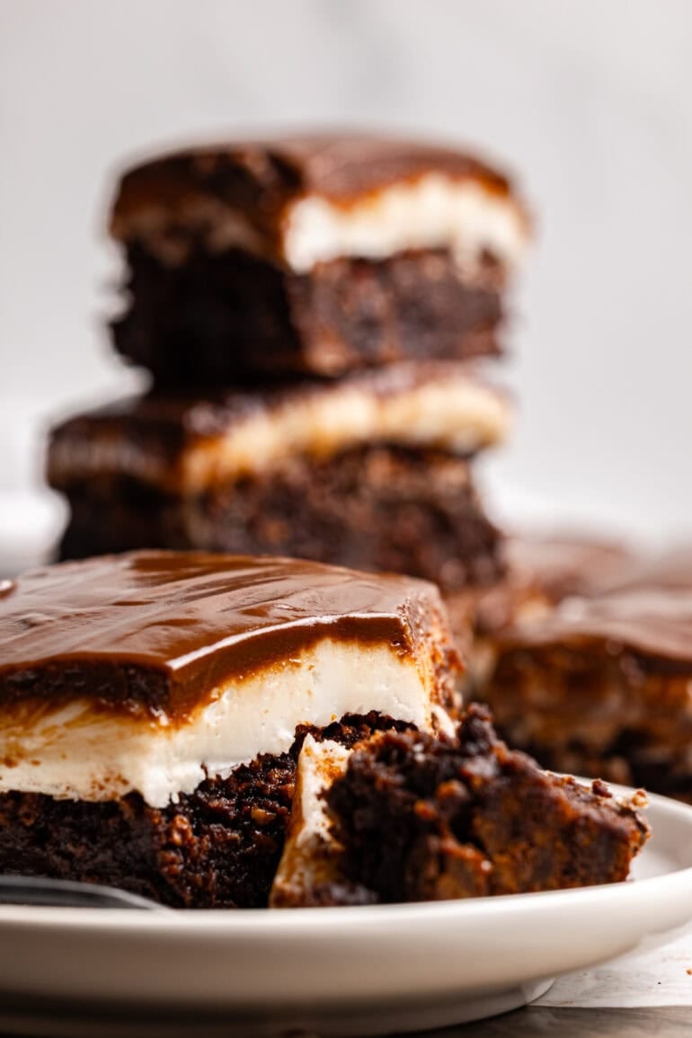 several homemade brownies with a white peppermint patty layer topped with glossy chocolate