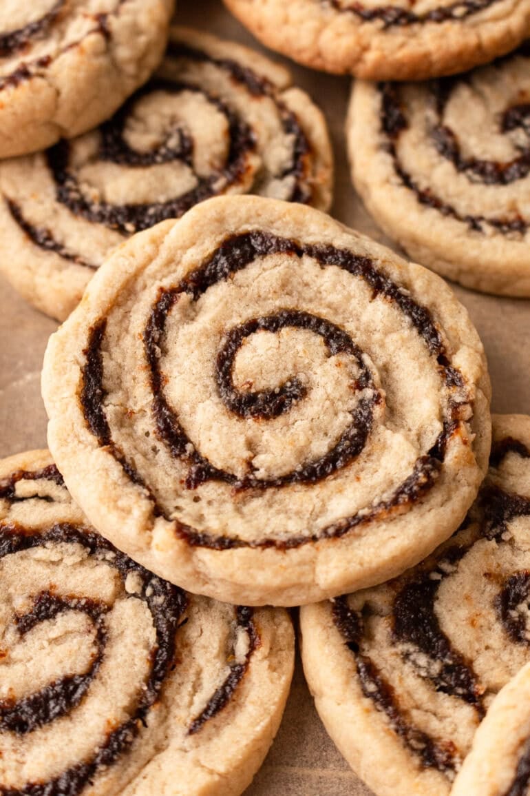 a closeup of a golden raising pinwheel cookie with several more cookies in the background