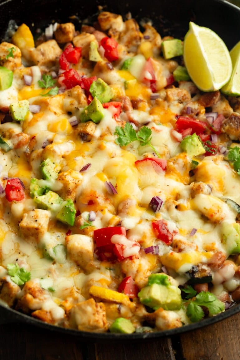 melted cheese all over chunks of chicken, tomatoes, zucchini, avocado, etc