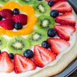 This sugar cookie fruit pizza is perfect for summer. Decorated with tangy cream cheese frosting and fresh fruit - it looks and tastes absolutely delicious.