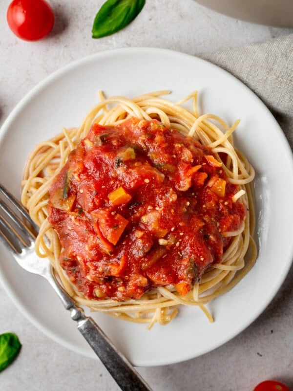 a photo of vegetable marinara on top of cooked angel hair pasta
