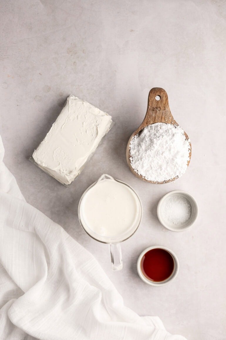 a photo of all the ingredients for whipped cream cream cheese frosting in separate small bowls