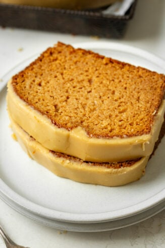 a photo of two slices of homemade apple bread stacked on each other topped with brown sugar icing