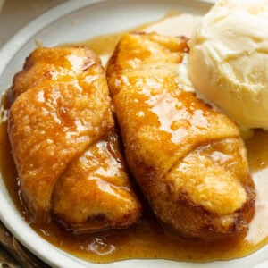 Warm apple dumpling served with a scoop of vanilla ice cream and brown sugar sauce.