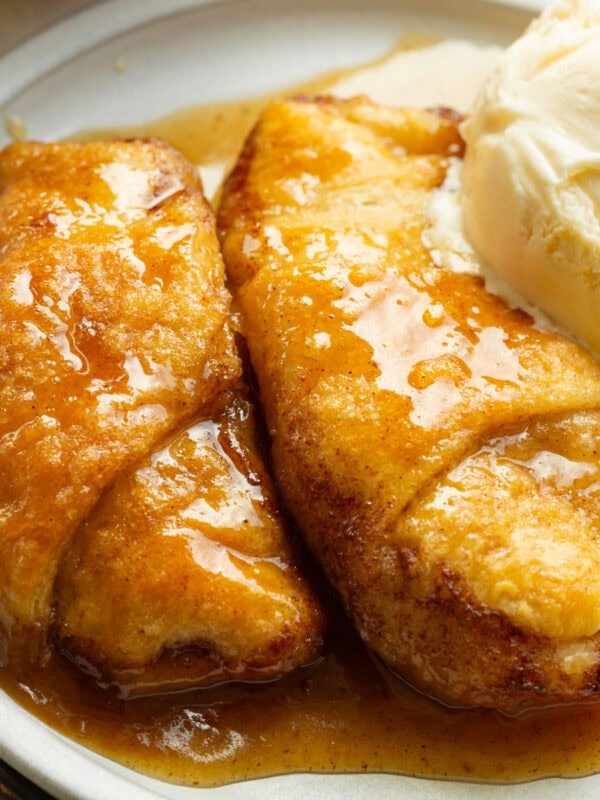 Warm apple dumpling served with a scoop of vanilla ice cream and brown sugar sauce.