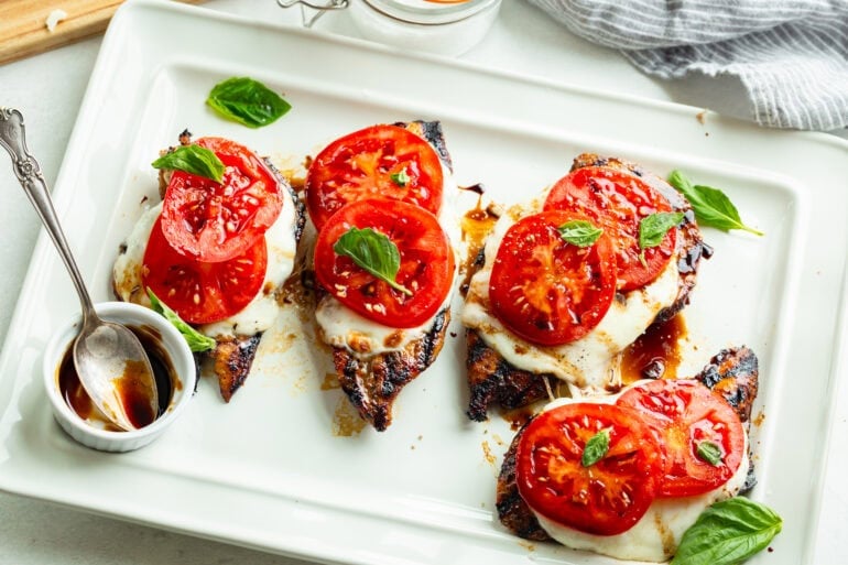 Four marinated grilled chicken breasts capri-style, sprinkled with melted mozzarella, tomato slices and fresh basil.