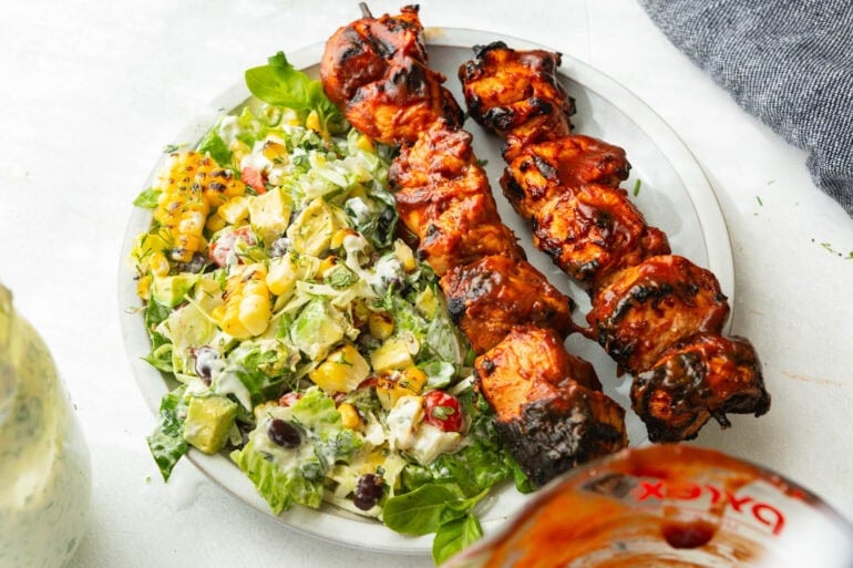 a dinner plate with creamy ranch salad with bbq chicken skewers