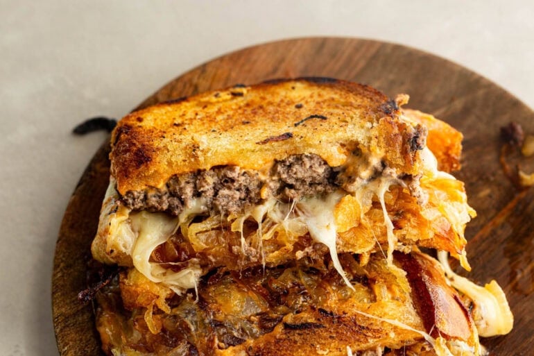 a patty melt turned up on its side so you can see the inside of the juicy, cheesy sandwich