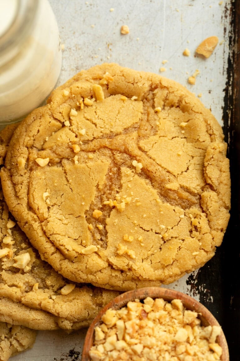 A photo taken on top of a large peanut butter cookie with chopped peanuts sprinkled on top