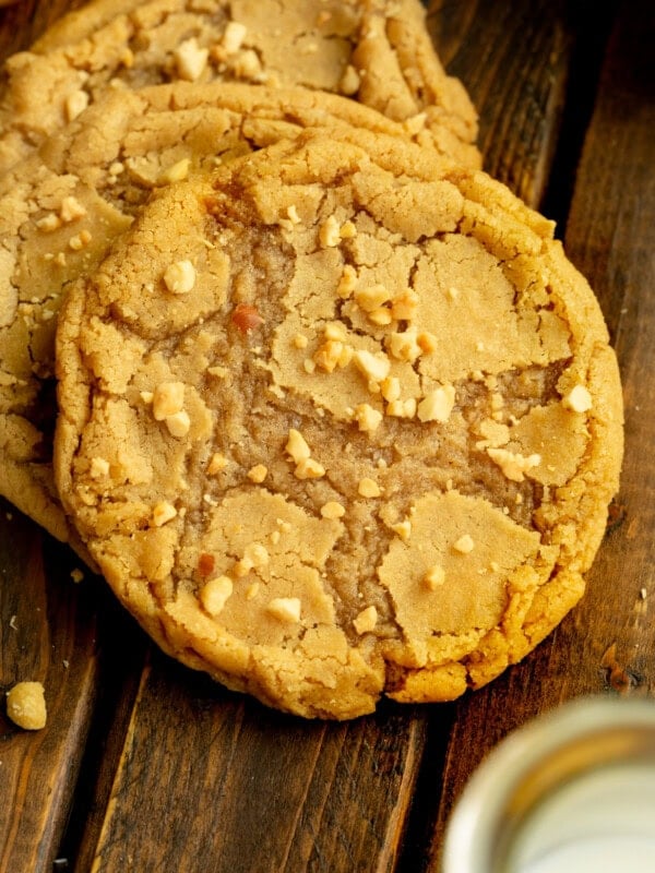 a photo of a large bakery style peanut butter cookie with chopped peanuts sprinkled on top