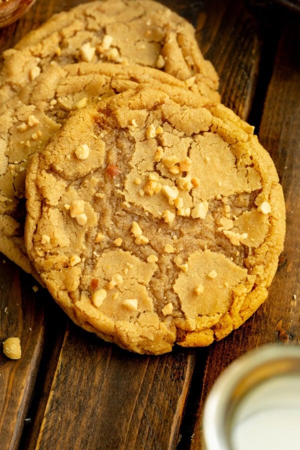 a photo of a large bakery style peanut butter cookie with chopped peanuts sprinkled on top