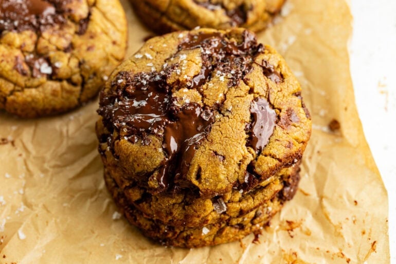 a stack of brown butter pumpkin chocolate chip cookies with melty chocolate chunks
