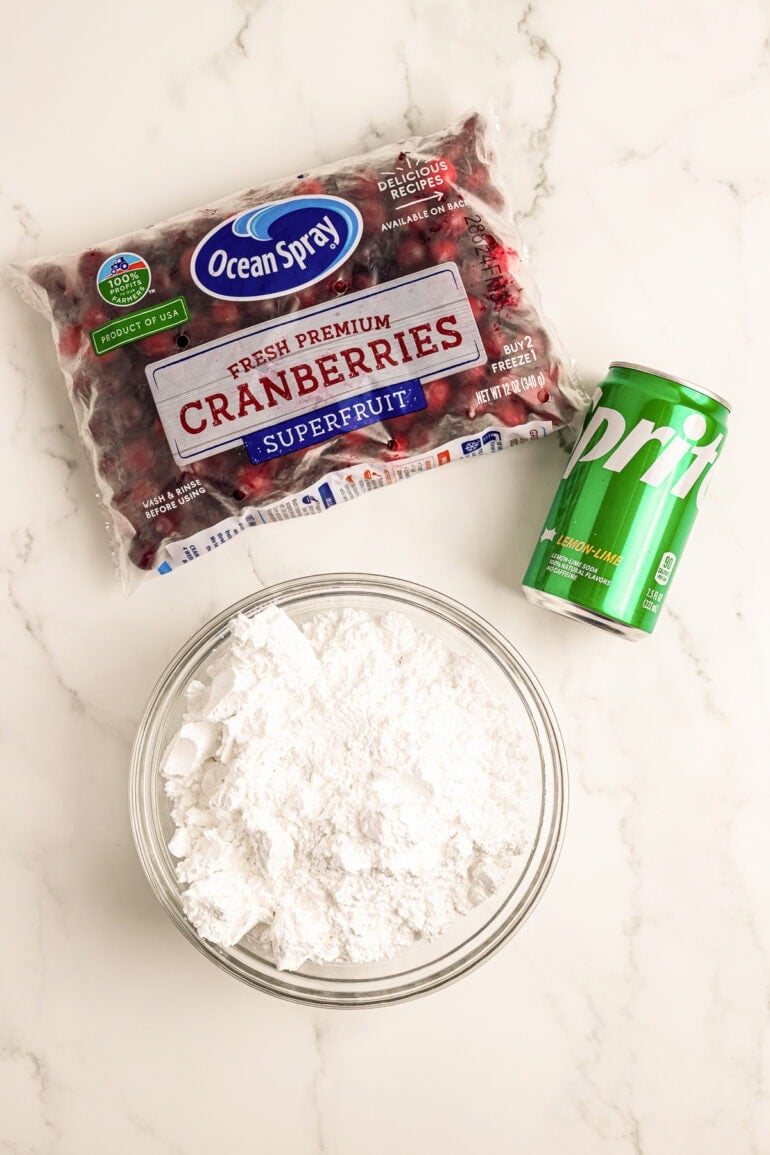 the three ingredients needed for candied cranberries - a bag of whole cranberries, a can of sprite and a bowl of powdered sugar