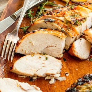 a roasted turkey breast that has sliced with one slice turned to show the cross section of the juicy turkey