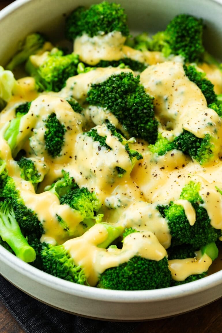 Pour creamy cheddar cheese sauce over fresh steamed broccoli sprinkled with black pepper