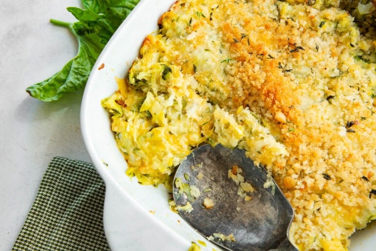 Zucchini casserole being served from a 9x13-inch baking dish