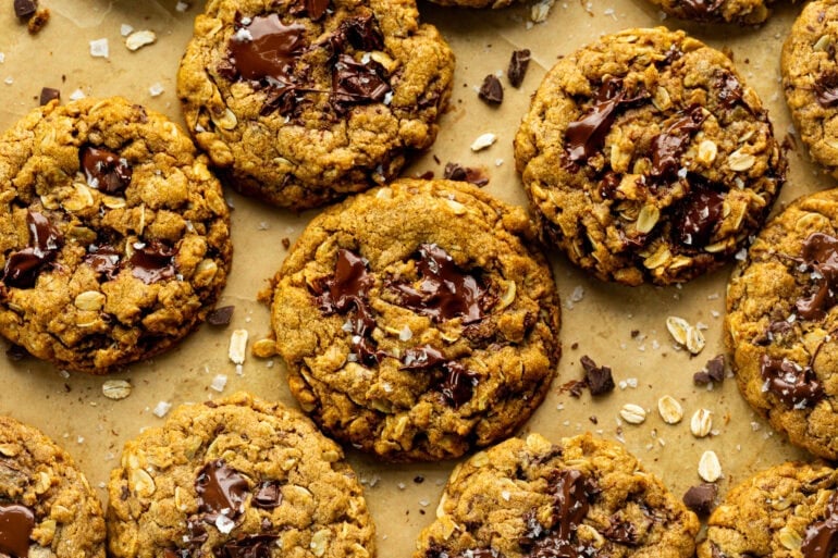 several baked pumpkin oatmeal chocolate chip cookies on a piece of brown parchment paper