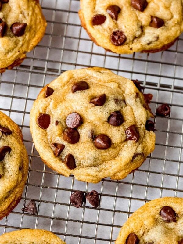 Baked chocolate chip cookies on a cooling rack.