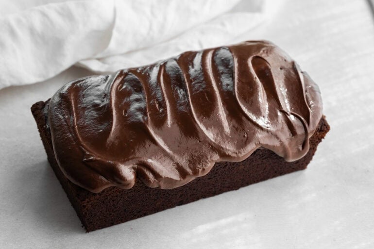 A loaf of chocolate pumpkin bread with a chocolate frosting layer