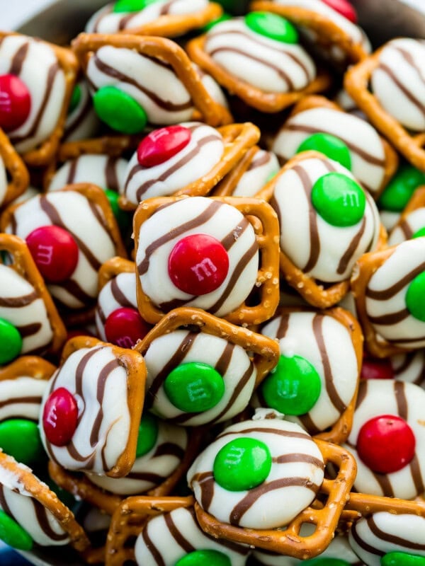 A bowl of m&m pretzel hugs with red and green candies on top