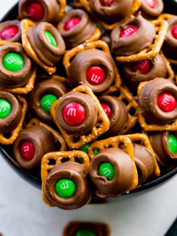 a white bowl full of rolo pretzels with m&ms on top