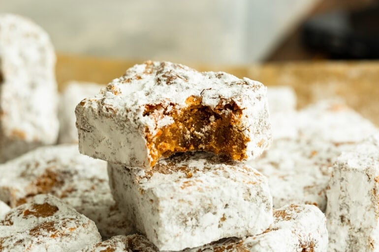 a stack of peanut butter bars with a bite taken out of the corner of the top one so you can see the inside
